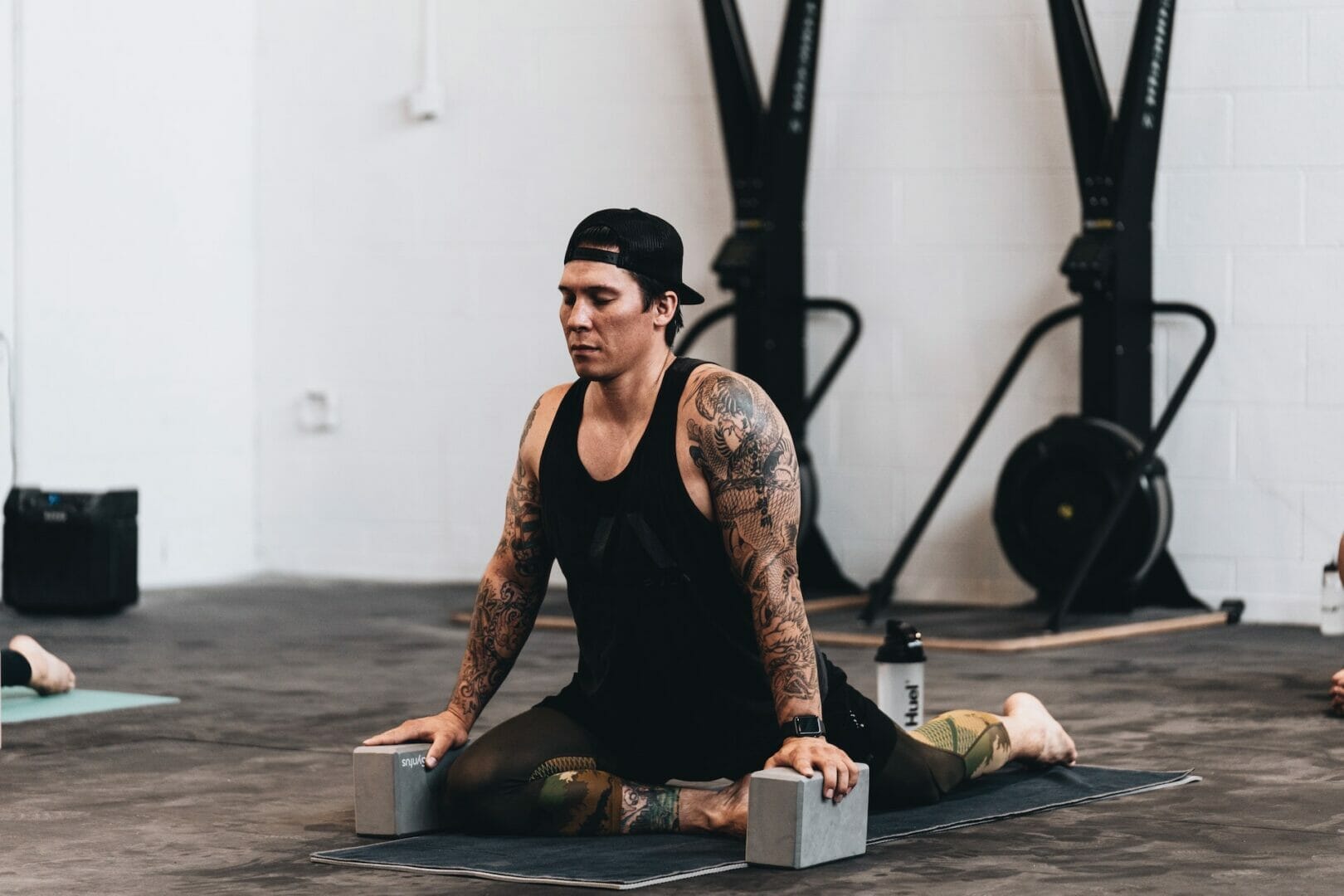 Why Should You Stretch? 1 man on a yoga mat stretching in the gym